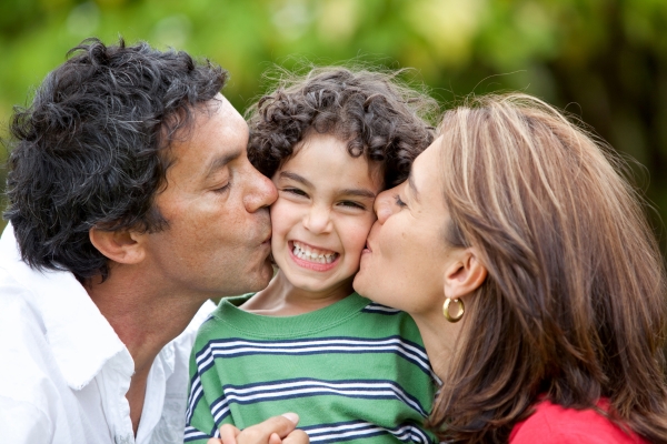 proud parents kissing smiling son