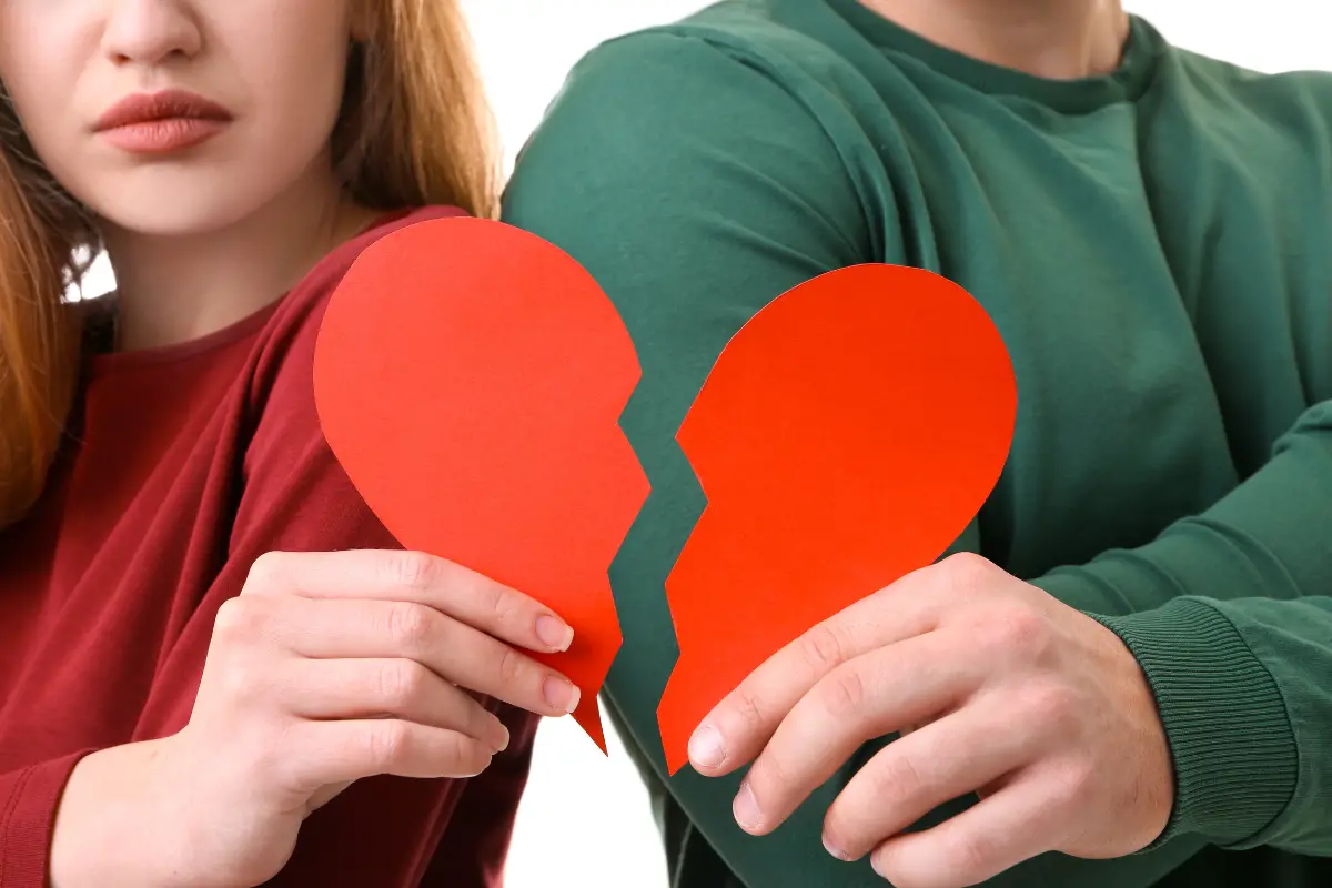 young couple hold halves of broken heart