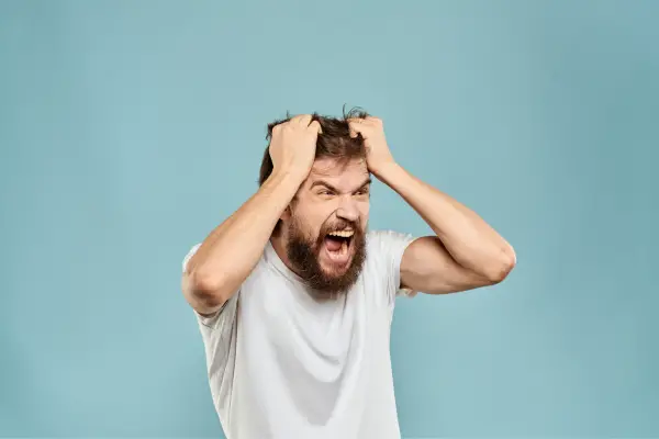 angry man holding hair after being knowledge wife affair 