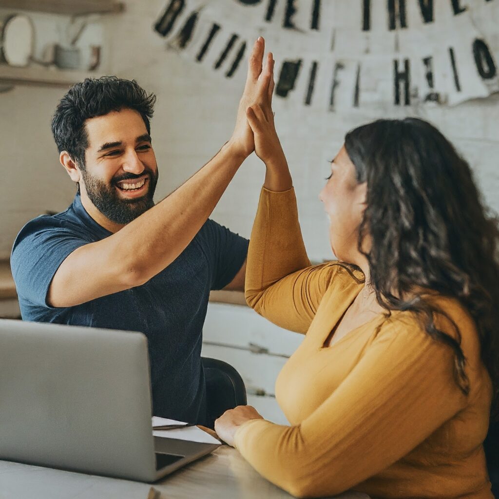 Couple high-fiving after achieving financial goal.