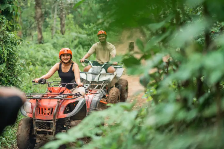 happy asian couple spending together in jungle riding ATV